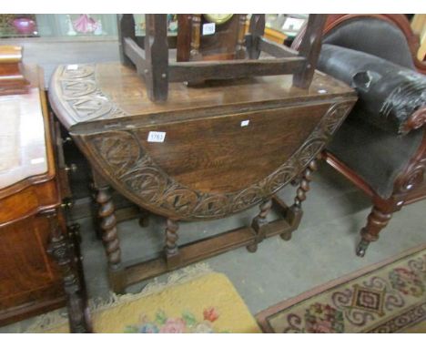 An oak barley twist gate leg table with carved edge.