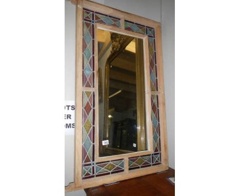A wall mirror with stained glass surround.