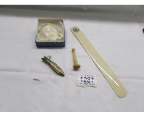 An advertising page turner, a 'fish' penknife, a carved necklace and one other item.