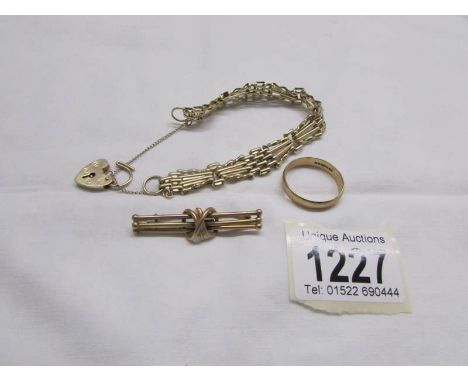 A 9ct gold gate bracelet (Hall marked A.S.J, London 1973 or 1979), a 9ct gold knot brooch and a band ring (Hall marked L&gt;W