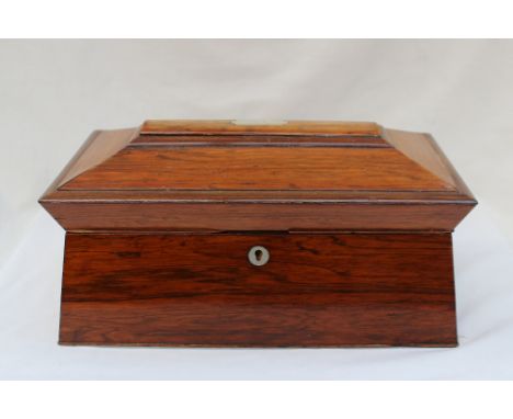 A Victorian rosewood sarcophagus shaped tea caddy, the domed top enclosing a fitted interior of two lidded compartment and a 