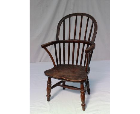 A 19th century Child's Windsor stick back elbow chair on four turned legs united by stretchers, 67cm high 