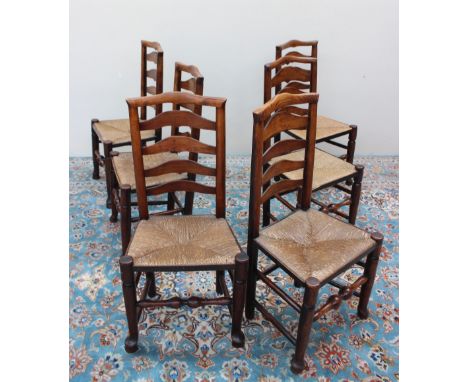 A set of six 19th century style oak ladder back dining chairs, with a rush seat on shaped legs (6)