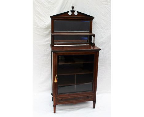 An Edwardian rosewood music cabinet, with a central urn and architectural pediment, mirrored back and shelf, the base with a 