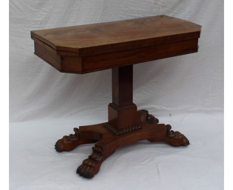 An early 19th century mahogany card table, the rectangular top with cut corners enclosing a baize interior and shallow frieze