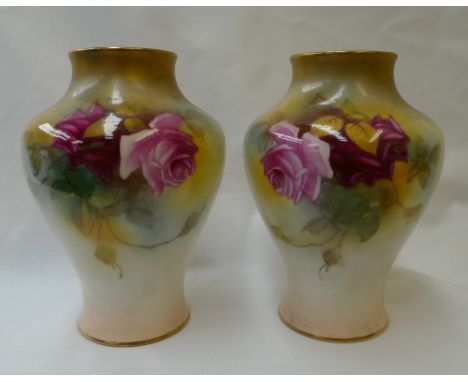 A pair of Royal Worcester porcelain inverted baluster vases painted with roses to an ivory ground, signed M Hunt, purple mark