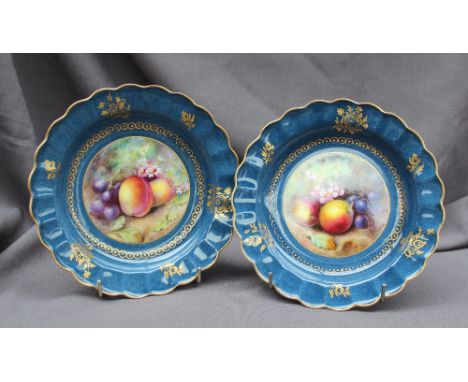 A pair of Royal Worcester bowls of shaped circular form with a gilt border, painted to the centre with fruit, including grape