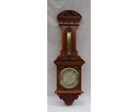 A 20th century carved walnut aneroid barometer carved with a shell and leaves, with a silvered dial and a mercury thermometer