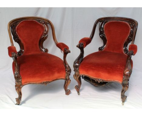 A pair of Victorian walnut framed library chairs, with a pad upholstered back and seat on turned legs and ceramic casters