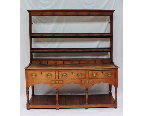 An 18th century South Wales oak dresser, the rack with a moulded cornice and two shelves, the base with a raised superstructu