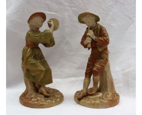 Pair of Worcester figures including a young lady playing a tambourine, seated on a tree stump, in greens and gold, the other 
