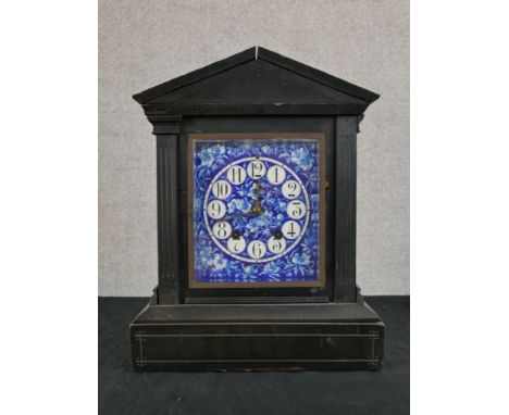 A late 19th century ebonised Architectural mantle clock, the blue and white enamel dial with black Arabic numerals and twin w