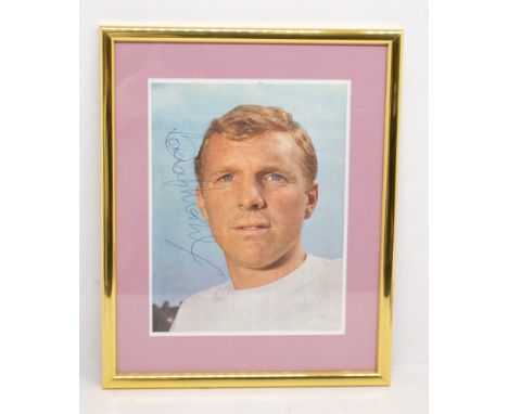 Bobby Moore: A framed and glazed printed photograph / magazine cutout of Bobby Moore, signed to the left hand side in blue bi