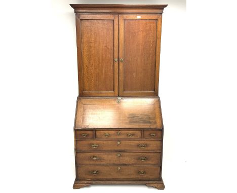 Georgian oak bureau bookcase, projecting cornice, two doors above single fall front enclosing fitted interior above three sho