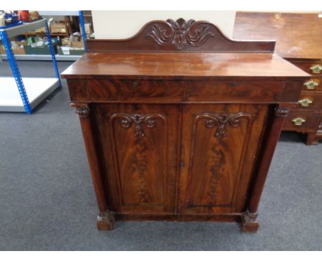 A Victorian mahogany double door cabinet fitted with drawers above and pillar column supports.