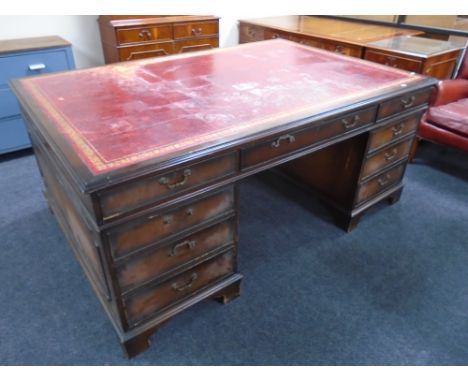 A mahogany nine drawer twin pedestal partners desk with red tooled leather inset panel, 78cm by 181cm by 124cm (a/f) CONDITIO