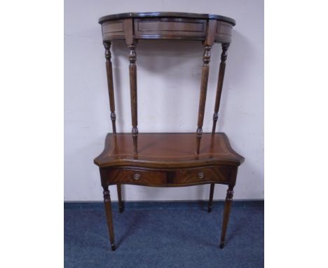 A mahogany serpentine fronted turnover top table fitted with leather inset panel and two drawers together with a further shap