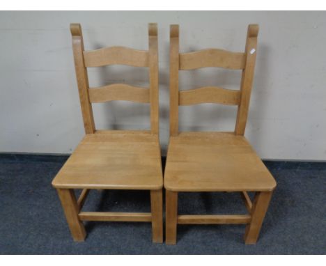 A pair of pine ladder back chairs.