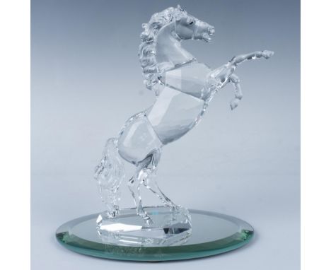 An elegant clear stallion rises powerfully on its hind legs, showcasing its striking black crystal eyes and a flowing mane, t