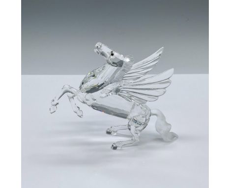A stunning clear crystal horse with wings, frosted crystal mane, and tabac eyes. It is shown resting on its frosted crystal t