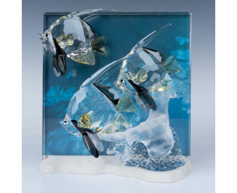 A trio of striking Moorish idol fish, adorned with beautiful yellow and black accents, swims gracefully together around a ser