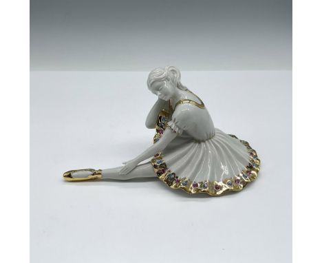 Figure in resting pose with leg extended. Dress is adorned with multicolor Swarovski crystals along with gilt accents on the 