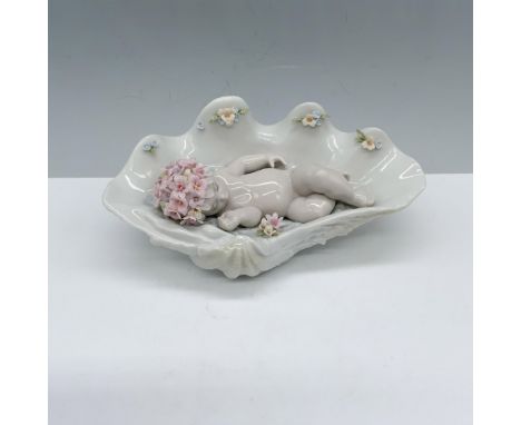 Charming glossy figure of a baby sleeping in a sea shell that has been decorated with flowers. Lladro backstamp. This item ha