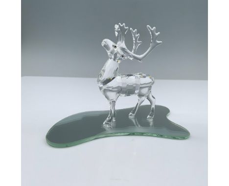 A clear reindeer figurine, standing gracefully on all fours with its head gently raised and adorned with melon colored eyes. 
