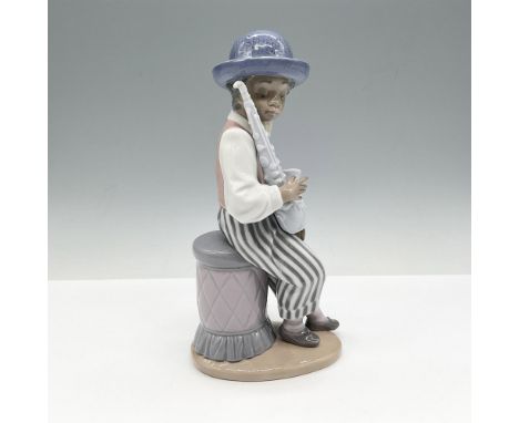 Glossy figure sitting on a cushioned bench holding his saxophone. Colored in gray, lavender and white. Lladro backstamp. 0100