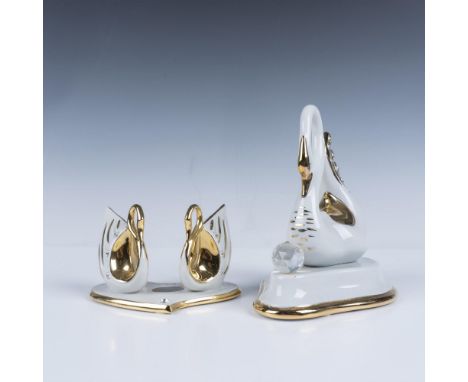 Fabulous pair of white porcelain gilt accented figurines that includes a swan behind a crystal with a heart on its back, and 