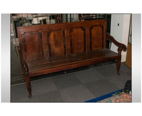 A Lancashire Oak Hall Bench with a four panelled Chamfered shaped back. On O G shaped arms. With a plank seat and terminating