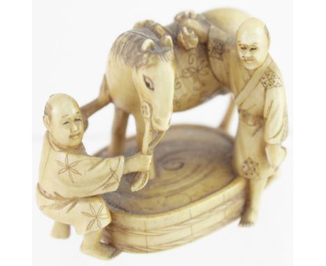 A 19th century ivory equestrian netsuke of two figures washing down a horse over a tub, signed to the base, width approx 4.5c