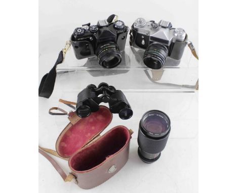 A brown leather cased set of military observer binoculars and a Zenit EM 35mm camera body with Helios lens, a Zenit E iwth He