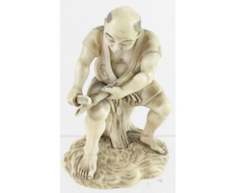 A 19th century Tokyo School ivory okimono of a seated gentleman carving bamboo, signed to a red lacquer panel to the base, he
