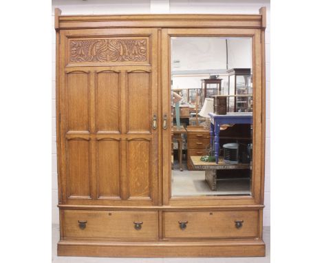 An Edward VII oak bedroom suite comprising triple wardrobe with matching dressing table mounted with shield-shaped mirror, he