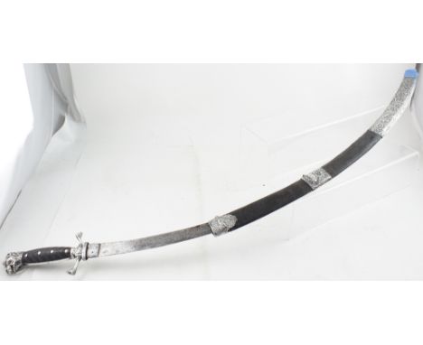 A 19th century North African or Middle Eastern sabre with lion head terminal and silver guard, in silver mounted leather scab