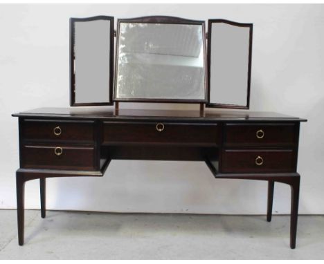 A 20th century Stag mahogany triple mirror back kneehole dressing table, one frieze drawer, two drawers to either side to tap