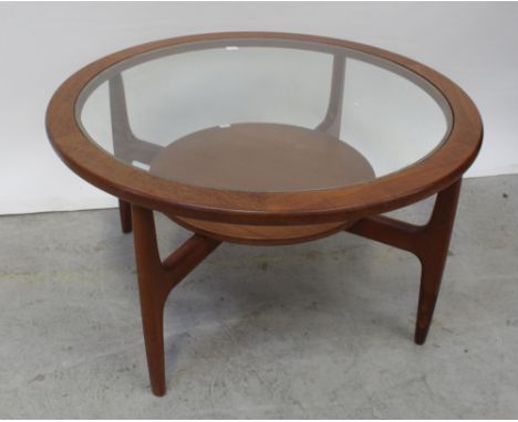 A circular G-Plan style teak coffee table with glass top surmounting four-legged frame base with circular shelf stretcher, di