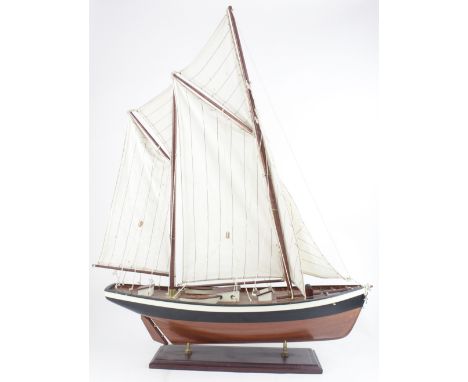 A mid/late 20th century small scratch-built model two-masted yacht with sails and rigging, on mahogany stand, height approx 7