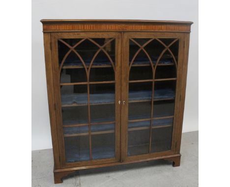 An Edward VII mahogany and satinwood banded bookcase, the glass panel doors with arched line inlaid glazing bars enclosing ad