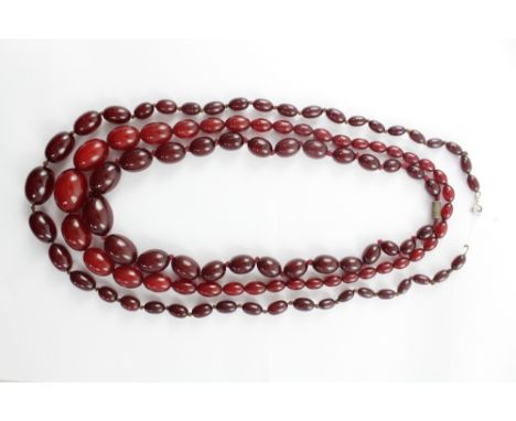 Three strings of cherry amber beads, one in light coloured red, length approx 62cm,  two in dark colouring (3).