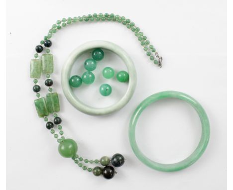 A small collection of jade and nephrite to include two bangles, loose beads and a bracelet.