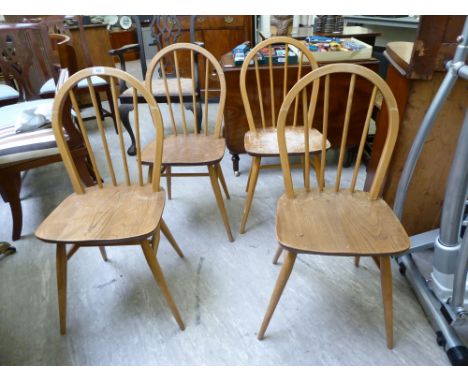 A set of four Ercol beech and elm framed hoop and stick back dining chairs, the solid seats raised on elliptically turned leg