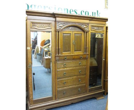 SUBSTANTIAL CIRCA 1900 OAK COMBINATION WARDROBE with Art Nouveau carved detail and architectural pillars flanking twin upper 