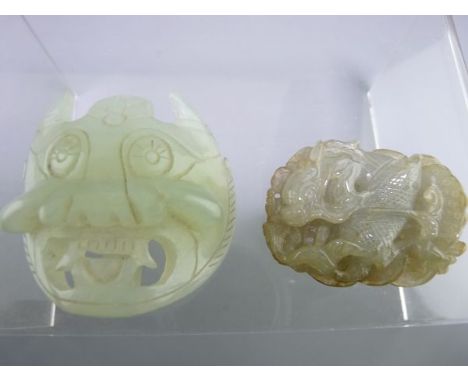 CARVED JADE PENDANT, 5cms, depicting a mythical beast amongst waves and carved jade belt mask, 5.5cms across