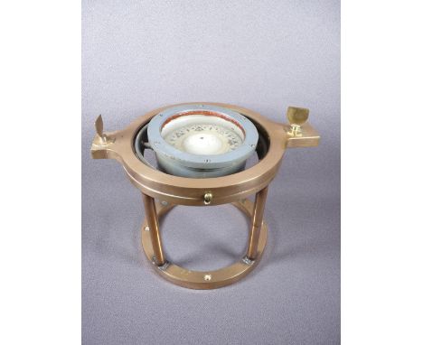A GIMBAL COMPASS ON A BRASS STAND