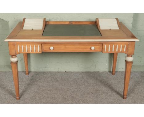 A vintage pine desk featuring painted highlights with leather inset top flanked by tambour compartments.  One tambour compart