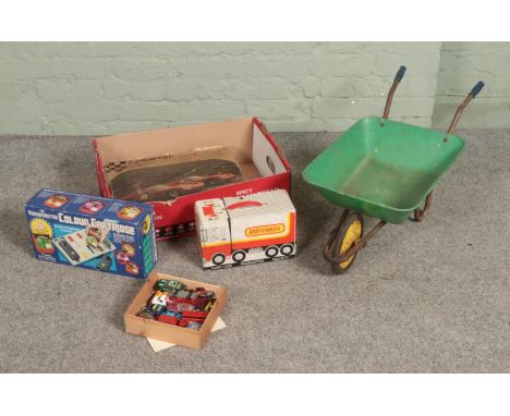 A box of vintage children's toys and games to include Revell Nova Home Racing Kit, Videomaster Colour Cartridge, wheelbarrow,