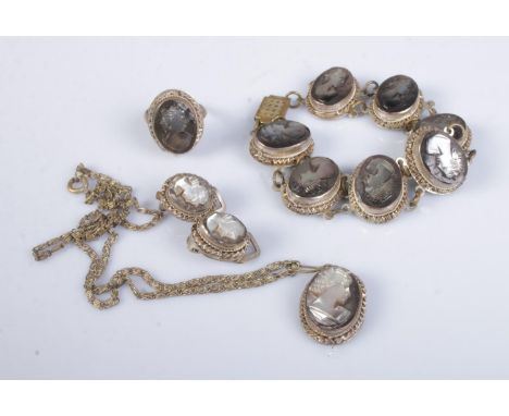 A white metal shell cameo jewellery suite featuring bracelet, ring, earrings and necklace. Makers mark GM stamped to all piec