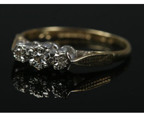 An 18ct gold three stone diamond ring in illusion setting. Size K. 1.6g.  